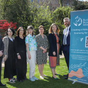 NPWS MX-76 People in a park on a sunny day standing next to a teal pull-up poster with logo