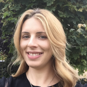 Smiling blonde woman, tree in background