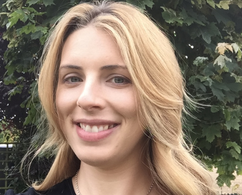Smiling blonde woman, tree in background