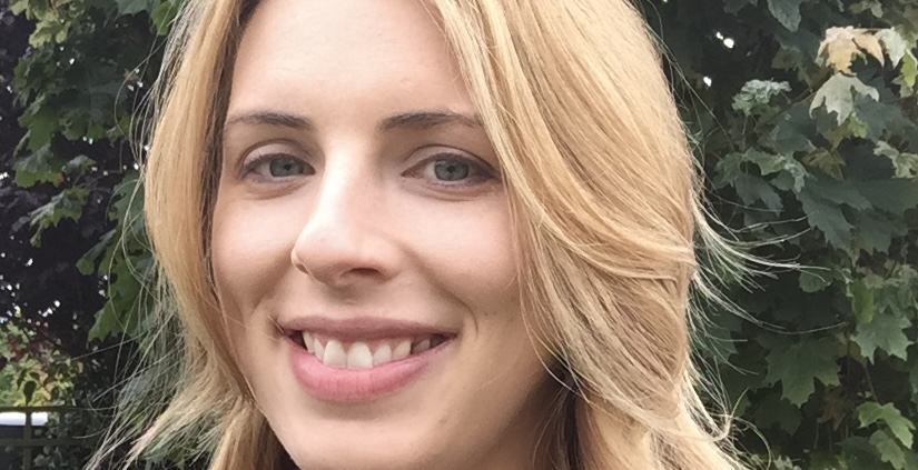 Smiling blonde woman, tree in background