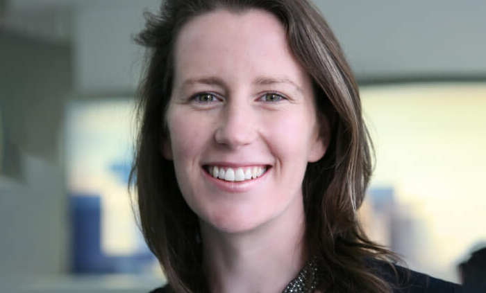 headshot of smiling brown haired woman in black