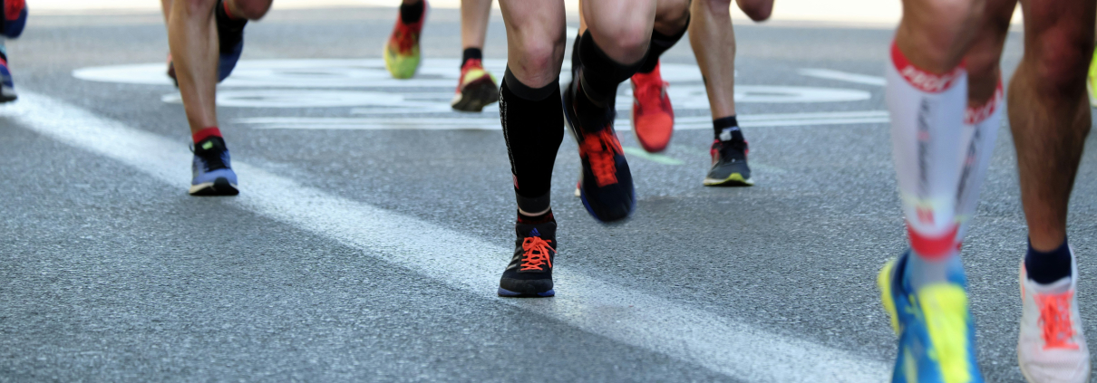 Legs of runners in brightly coloured shorts and trainers