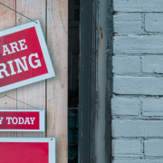 eric-prouzet-B3UFXwcVbc4-unsplash Picture of a door with a red sign with white text reading 'We are hiring'